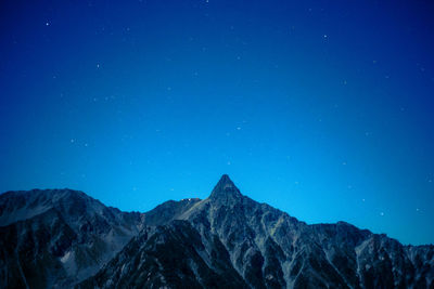 Scenic view of mountains against clear blue sky at night