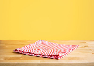 High angle view of umbrella on wooden table against yellow background