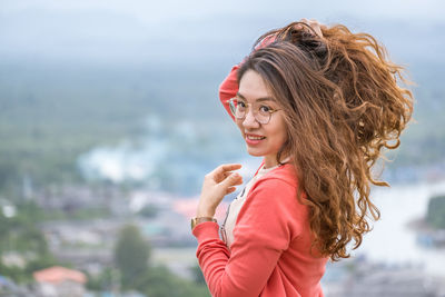 Portrait of smiling young woman standing outdoors