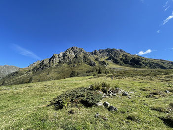 Scenic view of land and mountains against blue sky