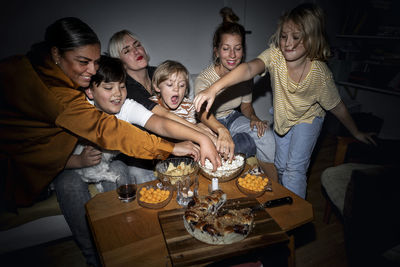 Family with kids snacking in living room