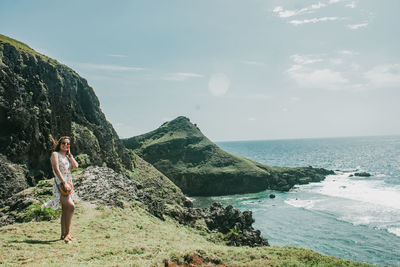 Young woman looking at sea against sky