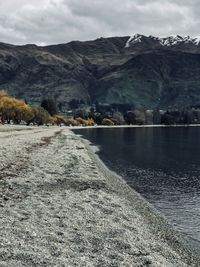 Scenic view of lake by mountains against sky