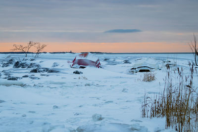 Scenic view of frozen lake against sky during sunset