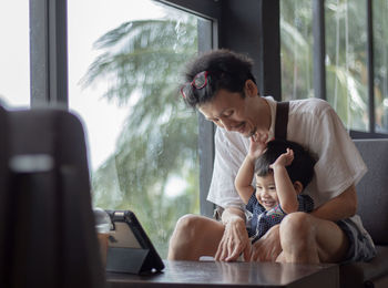 Smiling father with son looking at digital tablet