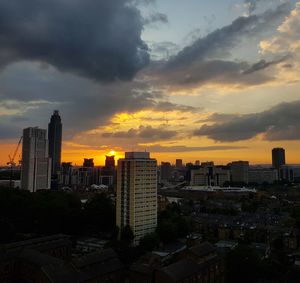 Buildings in city against sky during sunset