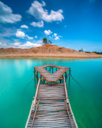 Pier over lake against blue sky