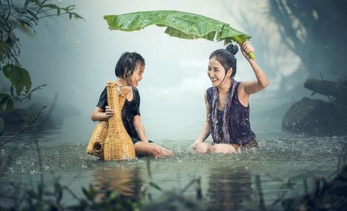 Full length of mother and daughter in rain