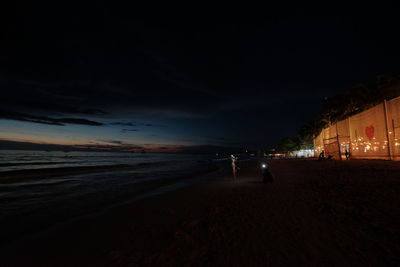 People at beach against sky at night