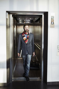 Businessman coming out from elevator in hotel