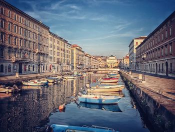 Boats moored on canal in city