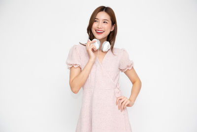 Portrait of a smiling young woman against white background