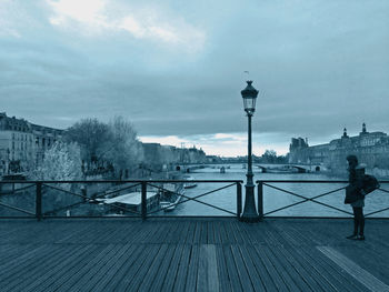 Woman standing on footbridge during winter