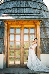 Side view of woman looking through window