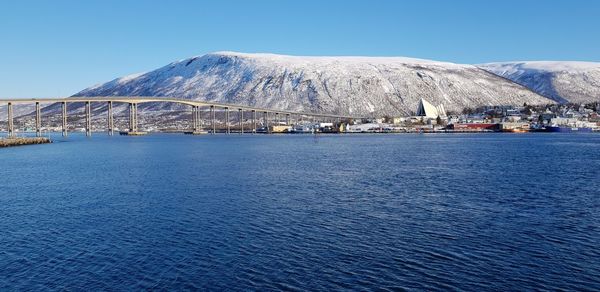 Scenic view of sea and mountains against clear blue sky