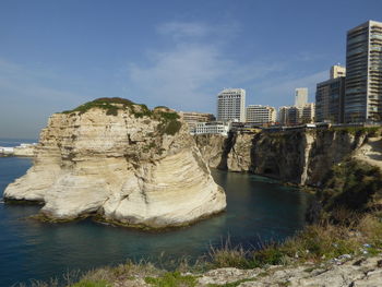 Rock formations in sea against sky