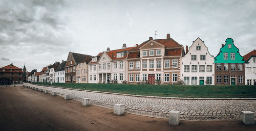 Houses by street in town against sky