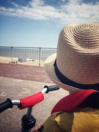 Rear view of boy with bicycle on road by beach 