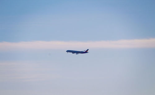 Low angle view of airplane flying against sky