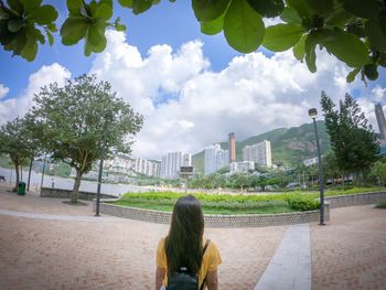 Rear view of woman looking at city against sky