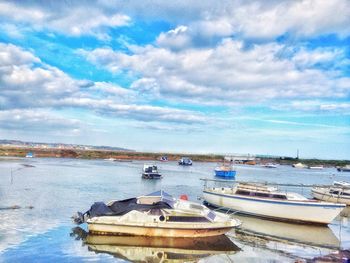 Boats in sea against cloudy sky