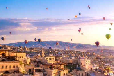 Hot air balloons flying over buildings in city