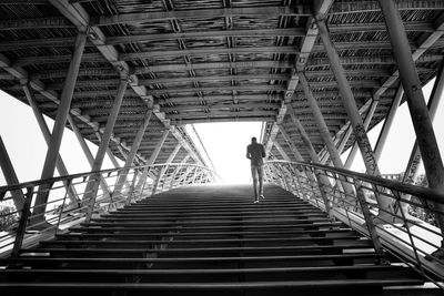 Rear view of man walking on staircase