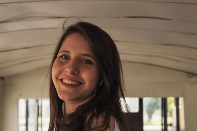 Portrait of young woman standing against wall