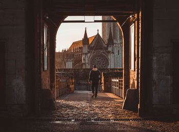 Rear view of man walking on footpath