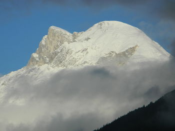 Low angle view of snowcapped mountains against sky