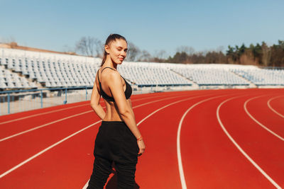 Portrait of female athlete standing on running track