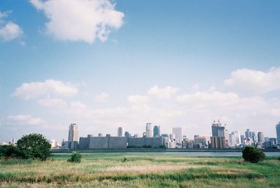 Buildings in city against cloudy sky