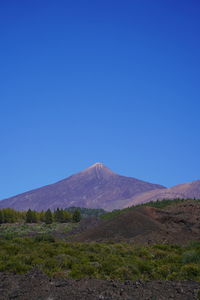 Scenic view of mountains against clear blue sky