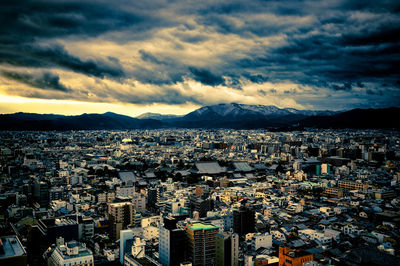 Aerial view of cityscape against dramatic sky