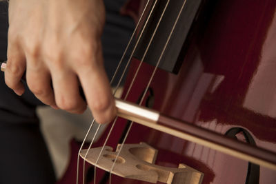 The woman is playing cello. detail of the cello in the hands.