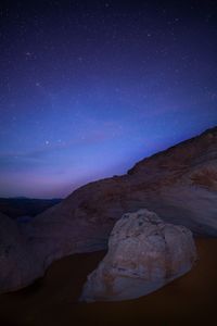 Scenic view of rock formation against sky at night