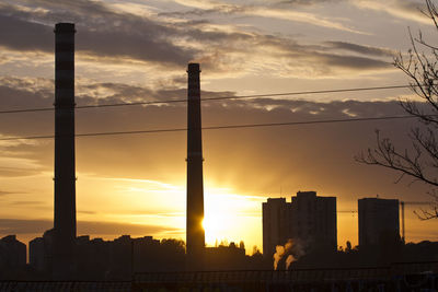 Silhouette buildings against sky during sunset