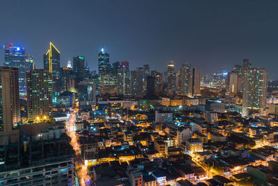 Illuminated cityscape against sky at night