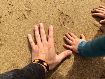 Close-up of hands on sand