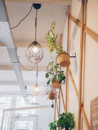 Low angle view of illuminated pendant lights hanging from ceiling at home