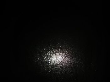 Low angle view of illuminated lamp against black background