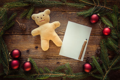 Close-up of christmas decorations with blank paper on pencil on table