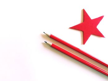 Directly above of pencils and star shape on white background