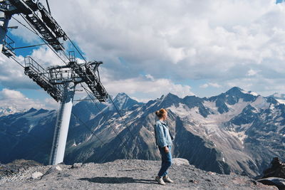 Man standing on snowcapped mountain against sky