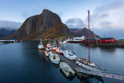 Boats moored at harbor against sky