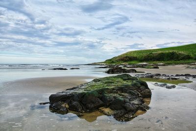 Rocks on beach against sky