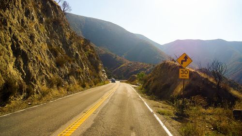 Road passing through mountains against sky