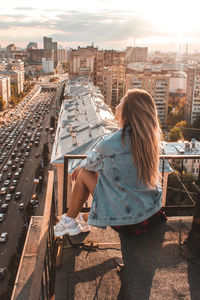Rear view of woman against buildings in city