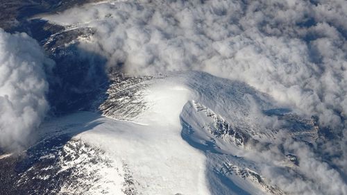 High angle view of snow covered mountains against sky