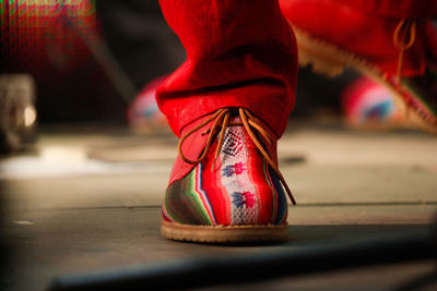Low section of person wearing red shoes